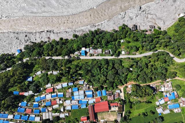 An aerial view shows damaged houses covered in sludge in the aftermath of the August 26 flash flood, at Betrawati Bazaar in Nepal's Rasuwa district on September 28, 2026. The Himalayan nation suffered one of the worst catastrophes in its history late last month when a tsunami-like flood, triggered by a high-altitude glacial mountain collapse along the Nepal-China border, cut a swathe of destruction claiming more than 1,400 lives and leaving 5,000 unaccounted for. (Photo by PRAKASH MATHEMA / AFP)