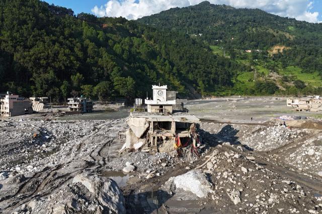 An aerial view shows damaged houses covered in sludge in the aftermath of the August 26 flash flood, at Betrawati Bazaar in Nepal's Rasuwa district on September 28, 2026. The Himalayan nation suffered one of the worst catastrophes in its history late last month when a tsunami-like flood, triggered by a high-altitude glacial mountain collapse along the Nepal-China border, cut a swathe of destruction claiming more than 1,400 lives and leaving 5,000 unaccounted for. (Photo by PRAKASH MATHEMA / AFP)