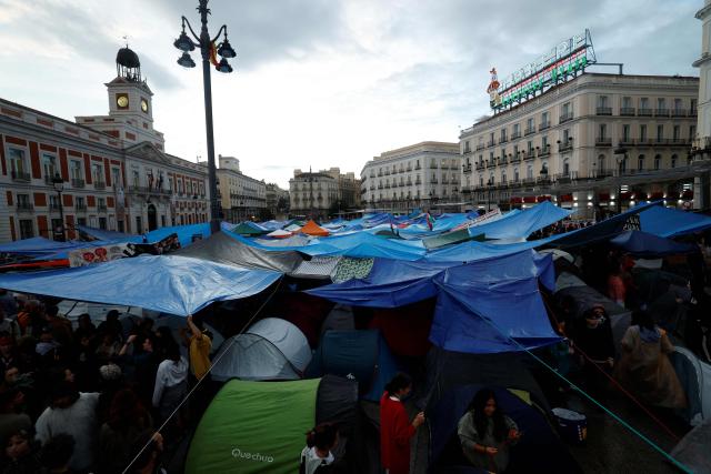 Demonstrators gather under tarps and tents in a camp set to protest against evictions and the housing crisis in front of the Presidency of the Community of Madrid on the Puerta del Sol plaza in Madrid on September 28, 2026. Demonstrators set up around 100 tents in Madrid's Puerta del Sol and Spain's main tenants' unions on September 25 urged the government to pass a new law to tackle the country's housing crisis after an 87-year-old was evicted from her Madrid home, sparking nationwide protests. (Photo by Oscar DEL POZO / AFP)