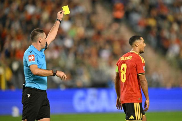 Slovenian referee Rade Obrenovic (L) shows a yellow card to Belgium's midfielder #08 Youri Tielemans (R) during the UEFA Nations League Group A1 football match between Belgium and France at King Baudouin Stadium in Brussels on September 28, 2026. (Photo by NICOLAS TUCAT / AFP)