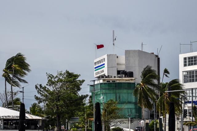 A red warning flag flies outside the port captain's office in the tourist port of Acapulco, Guerrero state, Mexico, on September 28, 2026, warning vessels not to sail ahead of the arrival of Tropical Storm Rachel. (Photo by Francisco  ROBLES / AFP)