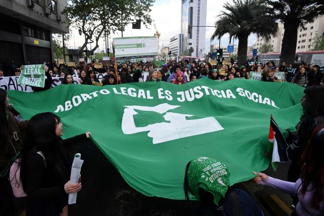 Women display a giant banner that reads in Spanish, "Legal abortion is social justice," during a demonstration in favor of the decriminalization of abortion on the occasion of the International Safe Abortion Day in Santiago on September 28, 2026. (Photo by RODRIGO ARANGUA / AFP)