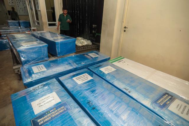 Coffins containing the identified remains of victims from the Virgo 8 ship disaster are prepared for repatriation to their respective hometowns at Syamsudin Noor Airport in Banjarbaru, South Kalimantan province, Indonesia on September 28, 2026. Dozens of victims identified by the South Kalimantan Regional Police Disaster Victim Identification (DVI) team are being returned to their families. (Photo by MUDA SAGALA / AFP)