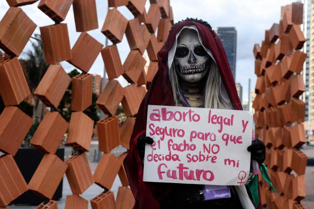 A demonstrator wearing skull face paint holds a sign reading, "Safe and legal abortion so the far right does not decide my future," during a demonstration marking the Global Day of Action for Access to Safe and Legal Abortion in Bogota on September 28, 2026. (Photo by Andrea Ariza / AFP)