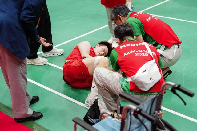 China's Liu Shengshu (C) receives medical attention after she and Tan Ning lost against South Korea's Lee So-hee and Baek Ha-na in the women's doubles badminton final during the 2026 Asian Games at the Ichinomiya City Municipal Gymnasium in Ichinomiya, Aichi prefecture on September 29, 2026. (Photo by Yuichi YAMAZAKI / AFP)