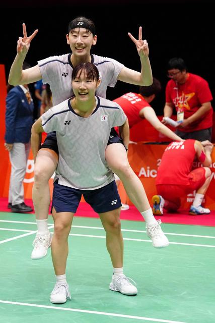 South Korea's Lee So-hee and Baek Ha-na celebrate their victory against China's Liu Shengshu and Tan Ning in the women's doubles badminton final during the 2026 Asian Games at the Ichinomiya City Municipal Gymnasium in Ichinomiya, Aichi prefecture on September 29, 2026. (Photo by Yuichi YAMAZAKI / AFP)