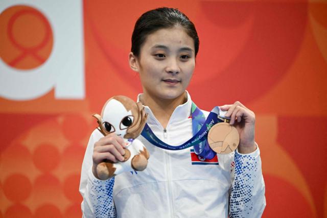 Bronze medallist North Korea's Jo Jin-mi celebrates on the podium during the victory ceremony of the women's 10m platform final diving event during the 2026 Asian Games at the Tokyo Aquatics Centre in Tokyo on September 29, 2026. (Photo by ANDREW CABALLERO-REYNOLDS / AFP)