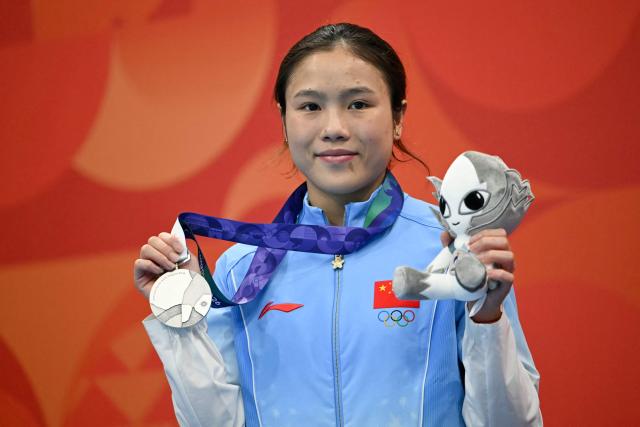Silver medallist China's Lu Wei poses on the podium during the victory ceremony of the women's 10m platform final diving event during the 2026 Asian Games at the Tokyo Aquatics Centre in Tokyo on September 29, 2026. (Photo by ANDREW CABALLERO-REYNOLDS / AFP)