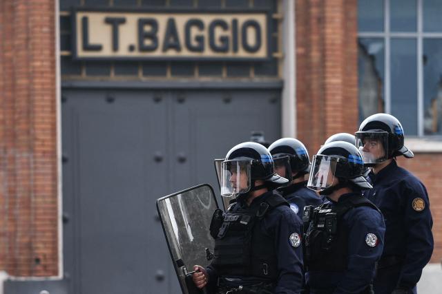 French national police in anti-riot gear look on as students carry out a blocking protest at the Cesar Baggio secondary school during a day of nationwide public sector strikes and demonstrations, in Lille, on September 29, 2026. Public sector workers, including firefighters, hold a one-day strike and demonstrations across France on September 29 in response to a call from a broad inter-union coalition, with the aim of putting pressure on the government two days before the presentation of the draft budget for 2027. (Photo by Sameer AL-DOUMY / AFP)
