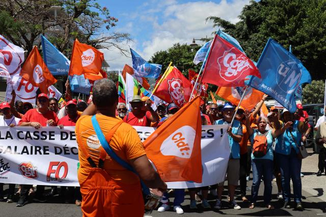 Protesters hold trade union flags as they take part in a rally during a day of nationwide public sector strikes and demonstrations, in Saint-Denis, French Indian Ocean island of La Reunion, on September 29, 2026. Public sector workers, including firefighters, hold a one-day strike and demonstrations across France on September 29 in response to a call from a broad inter-union coalition, with the aim of putting pressure on the government two days before the presentation of the draft budget for 2027. (Photo by Richard BOUHET / AFP)