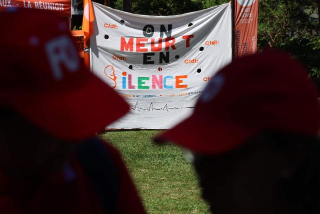 A photo shows a banner reading "We are dying in silence" at a rally during a day of nationwide public sector strikes and demonstrations, in Saint-Denis, French Indian Ocean island of La Reunion, on September 29, 2026. Public sector workers, including firefighters, hold a one-day strike and demonstrations across France on September 29 in response to a call from a broad inter-union coalition, with the aim of putting pressure on the government two days before the presentation of the draft budget for 2027. (Photo by Richard BOUHET / AFP)