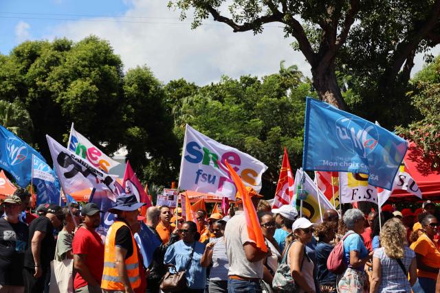Protesters hold trade union flags as they take part in a rally during a day of nationwide public sector strikes and demonstrations, in Saint-Denis, French Indian Ocean island of La Reunion, on September 29, 2026. Public sector workers, including firefighters, hold a one-day strike and demonstrations across France on September 29 in response to a call from a broad inter-union coalition, with the aim of putting pressure on the government two days before the presentation of the draft budget for 2027. (Photo by Richard BOUHET / AFP)