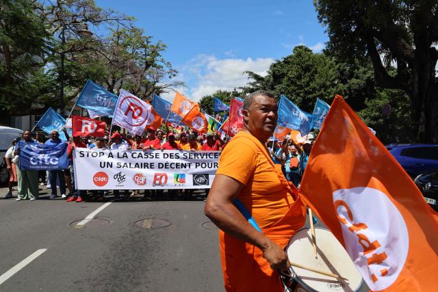 Protesters hold trade union flags as they take part in a rally during a day of nationwide public sector strikes and demonstrations, in Saint-Denis, French Indian Ocean island of La Reunion, on September 29, 2026. Public sector workers, including firefighters, hold a one-day strike and demonstrations across France on September 29 in response to a call from a broad inter-union coalition, with the aim of putting pressure on the government two days before the presentation of the draft budget for 2027. (Photo by Richard BOUHET / AFP)