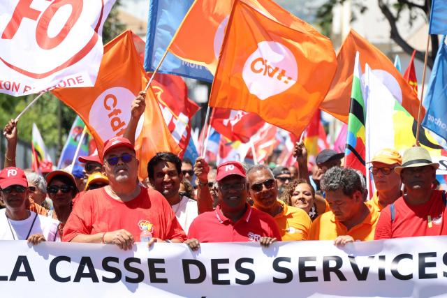 Protesters hold trade union flags as they take part in a rally during a day of nationwide public sector strikes and demonstrations, in Saint-Denis, French Indian Ocean island of La Reunion, on September 29, 2026. Public sector workers, including firefighters, hold a one-day strike and demonstrations across France on September 29 in response to a call from a broad inter-union coalition, with the aim of putting pressure on the government two days before the presentation of the draft budget for 2027. (Photo by Richard BOUHET / AFP)