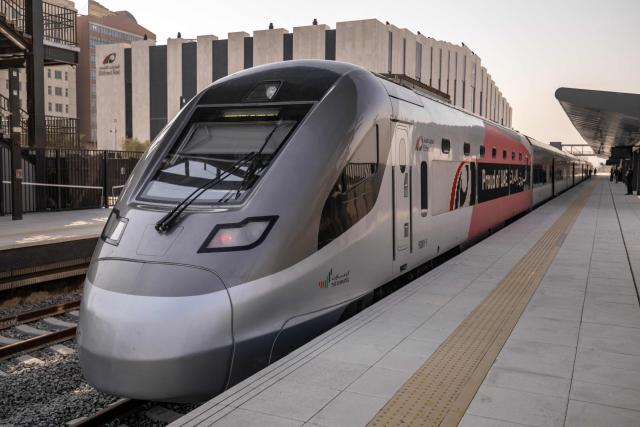CORRECTION / An Etihad Rail train arrives on September 29, 2026, during the inaugural passenger service connecting from Abu Dhabi's Mohamed Bin Zayed City station to Dubai's Yalayis station. (Photo by FADEL SENNA / AFP) / “The erroneous mention[s] appearing in the metadata of this photo by FADEL SENNA has been modified in AFP systems in the following manner: [TO DUBAI'S] instead of [AT DUBAI'S]. Please immediately remove the erroneous mention[s] from all your online services and delete it (them) from your servers. If you have been authorized by AFP to distribute it (them) to third parties, please ensure that the same actions are carried out by them. Failure to promptly comply with these instructions will entail liability on your part for any continued or post notification usage. Therefore we thank you very much for all your attention and prompt action. We are sorry for the inconvenience this notification may cause and remain at your disposal for any further information you may require.”