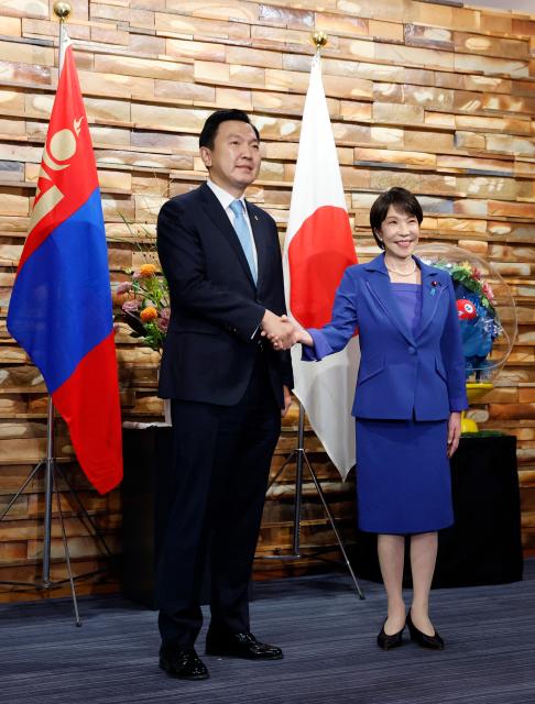 Mongolia's Prime Minister Nyam-Osoryn Uchral shakes hands with Japan's Prime Minister Sanae Takaichi during a meeting in Tokyo on September 29, 2026. (Photo by Kim Kyung-Hoon / POOL / AFP)