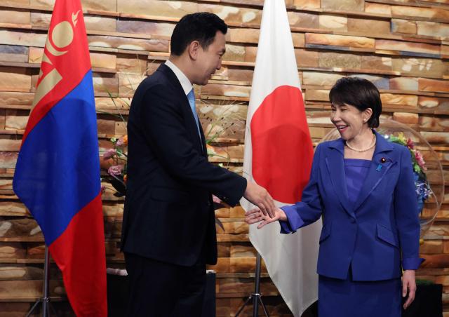 Mongolia's Prime Minister Nyam-Osoryn Uchral shakes hands with Japan's Prime Minister Sanae Takaichi during a meeting in Tokyo on September 29, 2026. (Photo by Kim Kyung-Hoon / POOL / AFP)