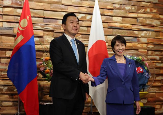 Mongolia's Prime Minister Nyam-Osoryn Uchral shakes hands with Japan's Prime Minister Sanae Takaichi during a meeting in Tokyo on September 29, 2026. (Photo by Kim Kyung-Hoon / POOL / AFP)