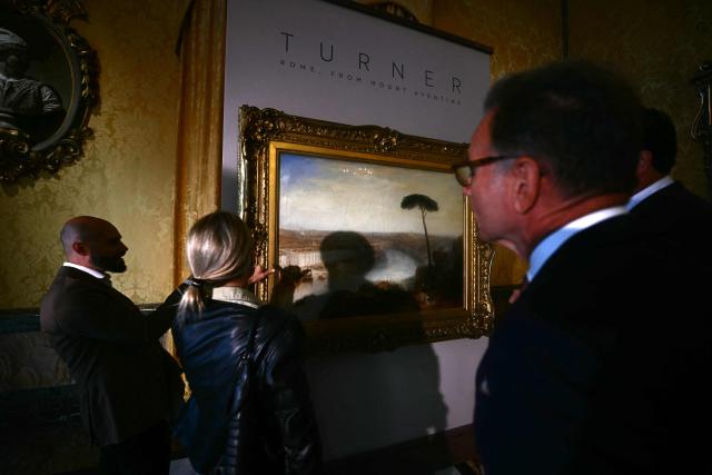People stand in front of a painting by William Turner "Rome, from Mount Aventine" painted in 1835, presented by Sotheby's auction house at Palazzo Rondinini in Rome on September 29, 2026. (Photo by Filippo MONTEFORTE / AFP)