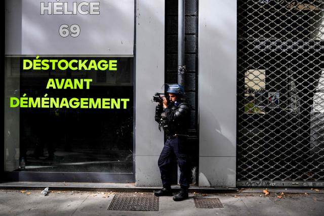 A gendarme films protesters taking part in a rally as part of a day of nationwide public sector strikes and demonstrations, in Lyon, on September 29, 2026. Public sector workers, including firefighters, hold a one-day strike and demonstrations across France on September 29 in response to a call from a broad inter-union coalition, with the aim of putting pressure on the government two days before the presentation of the draft budget for 2027. (Photo by OLIVIER CHASSIGNOLE / AFP)