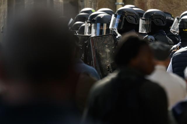 French national police in anti-riot gear keep position as protesters take part in a rally during a day of nationwide public sector strikes and demonstrations, in Nantes, western France, on September 29, 2026. Public sector workers, including firefighters, hold a one-day strike and demonstrations across France on September 29 in response to a call from a broad inter-union coalition, with the aim of putting pressure on the government two days before the presentation of the draft budget for 2027. (Photo by Loic VENANCE / AFP)