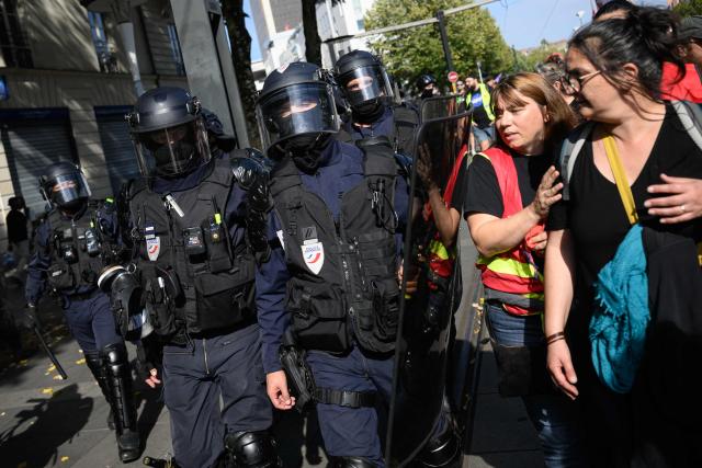 French national police in anti-riot gear flank protesters taking part in a rally during a day of nationwide public sector strikes and demonstrations, in Nantes, western France, on September 29, 2026. Public sector workers, including firefighters, hold a one-day strike and demonstrations across France on September 29 in response to a call from a broad inter-union coalition, with the aim of putting pressure on the government two days before the presentation of the draft budget for 2027. (Photo by Loic VENANCE / AFP)