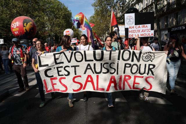 Protesters hold a banner reading "Evolution is for salaries as well" during a rally as part of a day of nationwide public sector strikes and demonstrations, in Paris, on September 29, 2026. Public sector workers, including firefighters, hold a one-day strike and demonstrations across France on September 29 in response to a call from a broad inter-union coalition, with the aim of putting pressure on the government two days before the presentation of the draft budget for 2027. (Photo by Anne-Christine POUJOULAT / AFP)