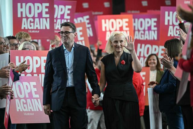Britain's Prime Minister Andy Burnham (centre L) and his wife Marie-France van Heel (centre R) are welcomed upon arrival ahead of his speech on the third day of the annual Labour Party conference in Liverpool, north-west England, on September 29, 2026. (Photo by Paul ELLIS / AFP)