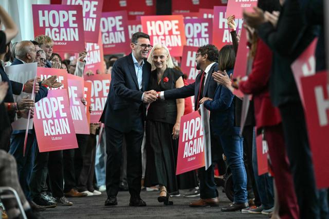 Britain's Prime Minister Andy Burnham (centre L) and his wife Marie-France van Heel (centre R) are welcomed upon arrival ahead of his speech on the third day of the annual Labour Party conference in Liverpool, north-west England, on September 29, 2026. (Photo by Paul ELLIS / AFP)