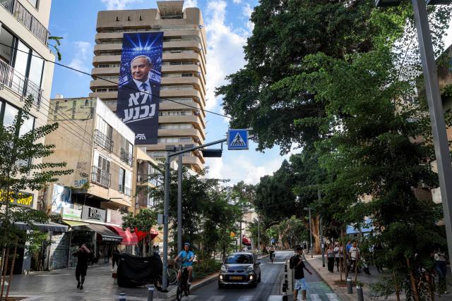 A giant electoral poster for Israeli Prime Minister Benjamin Netanyahu's Likud party with the slogan "no surrender" is displayed on the facade of a building in Tel Aviv on September 29, 2026 during campaigns ahead of the October 2026 legislative elections. (Photo by Jack GUEZ / AFP)
