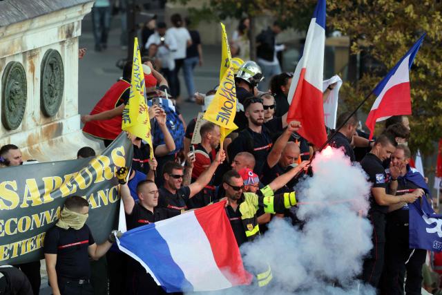 Firefighters hold flares and French flags on the July Column at Place de la Bastille during a day of nationwide public sector strikes and demonstrations in Paris on September 29, 2026. Public sector workers, including firefighters, hold a one-day strike and demonstrations across France on September 29 in response to a call from a broad inter-union coalition, with the aim of putting pressure on the government two days before the presentation of the draft budget for 2027. (Photo by Thomas SAMSON / AFP)