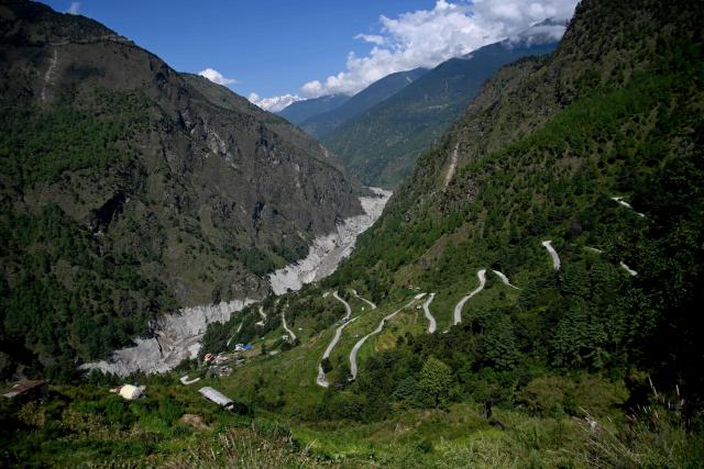 Residential houses overlook the Nepal-China Highway near the Bhote Koshi River at Syabrubesi in Nepal's Rasuwa district on September 29, 2026, in the aftermath of the August 26 flash flood. The Himalayan nation suffered one of the worst catastrophes in its history late last month when a tsunami-like flood, triggered by a high-altitude glacial mountain collapse along the Nepal-China border, cut a swathe of destruction claiming more than 1,400 lives and leaving 5,000 unaccounted for. (Photo by Prakash MATHEMA / AFP)