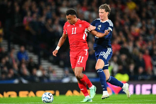 Scotland's defender #13 Jack Hendry (R) pulls back Switzerland's midfielder #11 Dan Ndoye (R) and is sent off during the UEFA Nations League, League B, Group 1 match football match between Scotland and Switzerland at Hampden Park in Glasgow, Scotland on September 29, 2026.  (Photo by ANDY BUCHANAN / AFP)