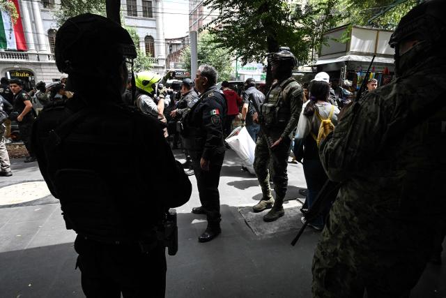 Navy personnel provide security as officials from the Secretariat of Citizen Security and the Mexican Institute of Industrial Property load packages of allegedly pirated goods seized during an operation at a shopping center in Mexico City on September 29, 2026. (Photo by Yuri CORTEZ / AFP)
