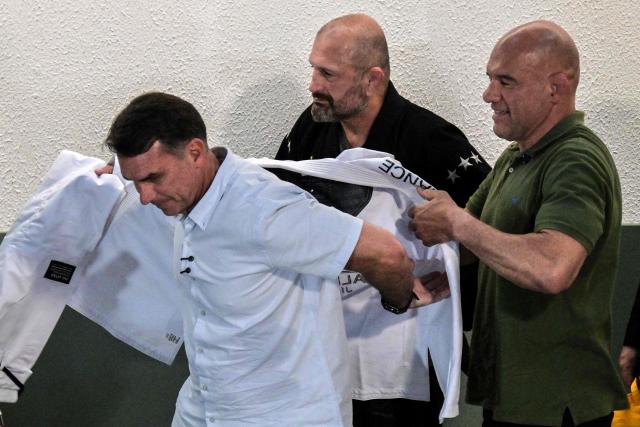Brazil's right-wing senator and presidential candidate Flavio Bolsonaro of the Liberal Party (PL) puts on a jiu-jitsu gi during a meeting with practitioners at a gym during a campaign rally in Sao Paulo, Brazil, on September 29, 2026. Brazil will hold presidential election on October 4, 2026. (Photo by Nelson ALMEIDA / AFP)
