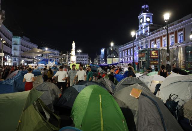 People gather at a protest camp against evictions and the housing crisis outside the headquarters of the Madrid regional government at Puerta del Sol in Madrid in the early hours of September 30, 2026. The Spanish government on September 29 approved measures including a ban on evictions until 2030 and the automatic renewal of tenant contracts following days of nationwide housing protests. But the measures hang in the balance as the left-wing coalition lacks a majority in a heavily fragmented parliament, which is due to vote on them on October 2. (Photo by Thomas COEX / AFP)