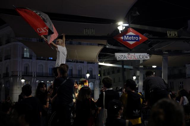 People gather at a protest camp against evictions and the housing crisis outside the headquarters of the Madrid regional government at Puerta del Sol in Madrid in the early hours of September 30, 2026. The Spanish government on September 29 approved measures including a ban on evictions until 2030 and the automatic renewal of tenant contracts following days of nationwide housing protests. But the measures hang in the balance as the left-wing coalition lacks a majority in a heavily fragmented parliament, which is due to vote on them on October 2. (Photo by Thomas COEX / AFP)
