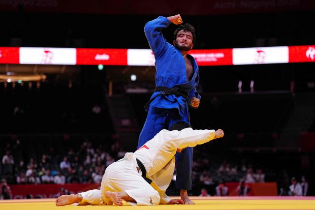 Bahrain's Sukhrob Boqiev (blue) celebrates a point against Japan's Hattori Shinsei in the men's 66kg judo elimination round at Aichi International Arena during the 2026 Asian Games in Nagoya on September 30, 2026. (Photo by Yuichi YAMAZAKI / AFP)