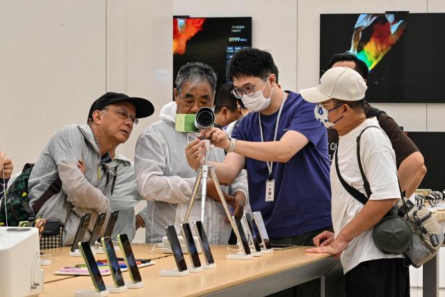 People visit a Huawei store in Shanghai on September 30, 2026. (Photo by Hector RETAMAL / AFP)