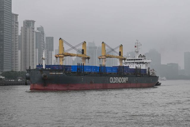 A cargo ship sails along the Huangpu River in Shanghai on September 30, 2026. (Photo by Hector RETAMAL / AFP)