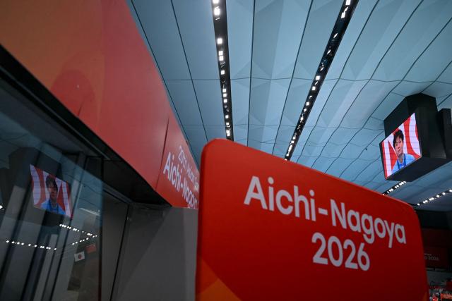 Gold medallist China's Chen Yiwen is seen on television as China's national anthem plays during the victory ceremony of the women's 3m springboard final diving event during the 2026 Asian Games at the Tokyo Aquatics Centre in Tokyo on September 30, 2026. (Photo by ANDREW CABALLERO-REYNOLDS / AFP)