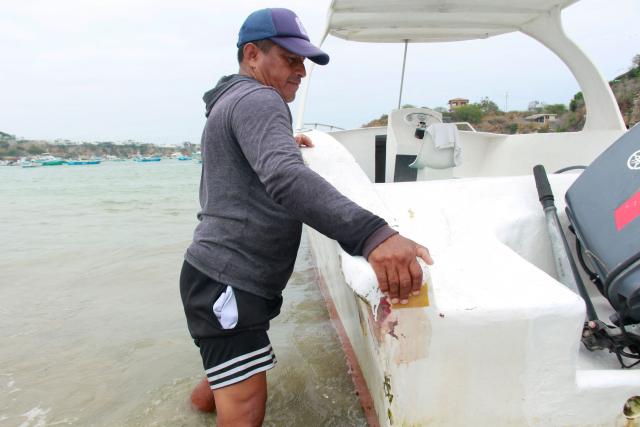 A fisherman pushes a boat in the San Pedro commune in Santa Elena, Ecuador, on September 18, 2026. Small-scale fishermen in the eastern Pacific -from the shores of Ecuador and Peru to those of Panama and Guatemala- are suffering the impact of ocean warming caused by the El Niño phenomenon, which forces several species to migrate to deeper waters and leaves nets half empty and coastal communities in crisis. (Photo by Gerardo MENOSCAL / AFP)