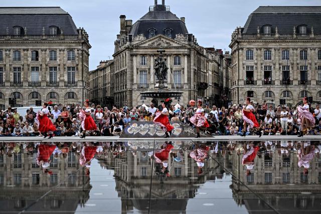 Dancers run along the Mirroir d'Eau (Water Mirror) reflecting pool before an attempt to break the world record for the highest number of participants in a French Cancan performance, in Bordeaux, south-western France on September 30, 2026. (Photo by Christophe ARCHAMBAULT / AFP)