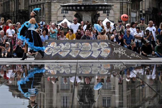Dancers run along the Mirroir d'Eau (Water Mirror) reflecting pool before an attempt to break the world record for the highest number of participants in a French Cancan performance, in Bordeaux, south-western France on September 30, 2026. (Photo by Christophe ARCHAMBAULT / AFP)