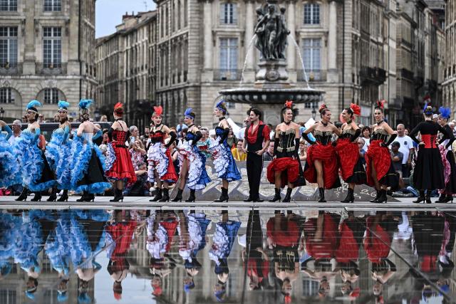 Dancers stand along the Mirroir d'Eau (Water Mirror) reflecting pool before an attempt to break the world record for the highest number of participants in a French Cancan performance, in Bordeaux, south-western France on September 30, 2026. (Photo by Christophe ARCHAMBAULT / AFP)