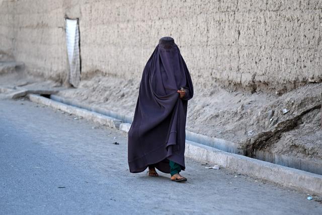 An Afghan burqa-clad woman walks along a street in Spin Ziarat village in the Dand district of Afghanistan's Kandahar province on September 30, 2026. (Photo by Sanaullah SEIAM / AFP)