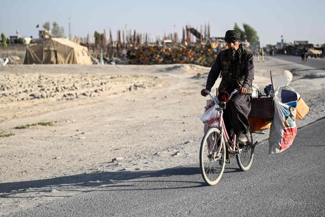 An Afghan man carries recyclable waste on a bicycle along a road in Qasam Pul village in the Dand district of Afghanistan's Kandahar province on September 30, 2026. (Photo by Sanaullah SEIAM / AFP)