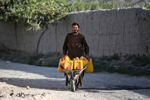 An Afghanistan man pushes a handcart loaded with water canisters in Qasam Pul village in the Dand district of Afghanistan's Kandahar province on September 30, 2026. (Photo by Sanaullah SEIAM / AFP)