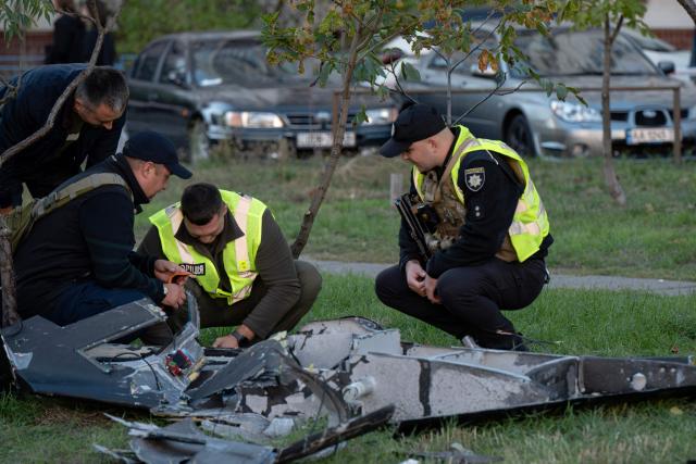 Ukrainian police investigators examine debris of a Russian drone that crashed near a children's playground among residential buildings and did not detonate, in Kyiv on September 30, 2026, amid the Russian invasion of Ukraine. (Photo by Genya SAVILOV / AFP)