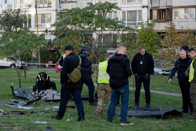 Ukrainian police investigators examine debris of a Russian drone that crashed near a children's playground among residential buildings and did not detonate, in Kyiv on September 30, 2026, amid the Russian invasion of Ukraine. (Photo by Genya SAVILOV / AFP)